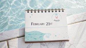 Página del calendario del zodíaco del 21 de febrero con el símbolo de Piscis y un diseño inspirado en el agua.